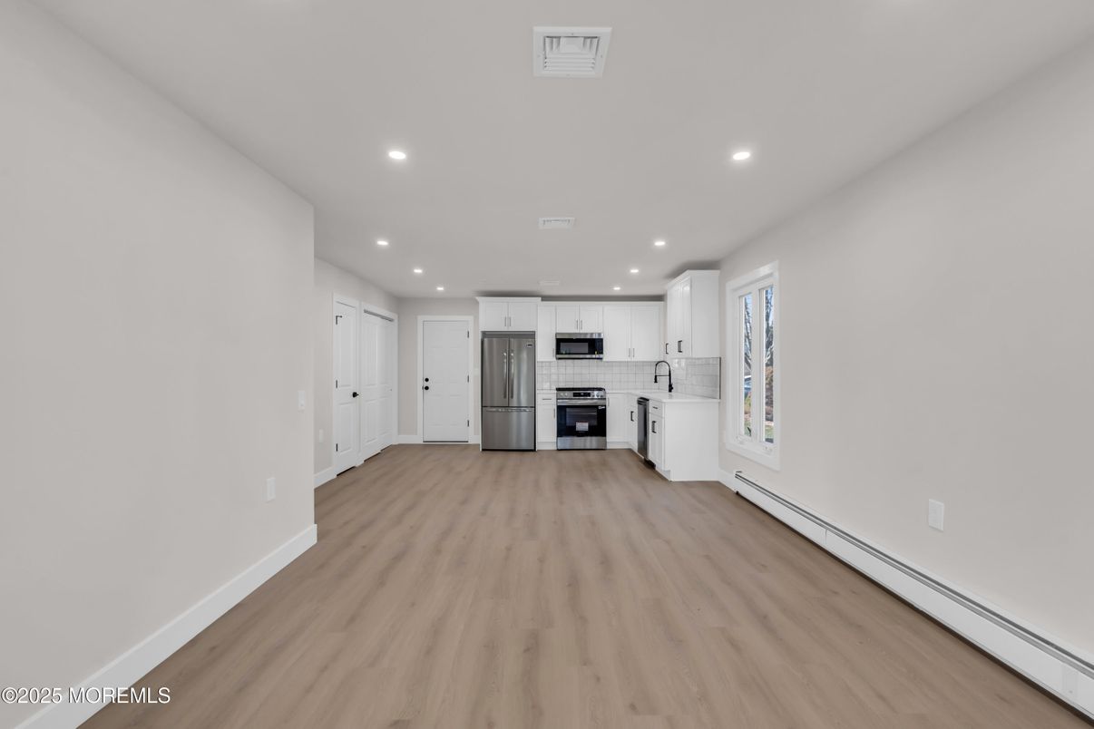 Empty room, Interior, Kitchen, Recessed Lighting, Stainless Steel Appliances, Wood Texture Flooring