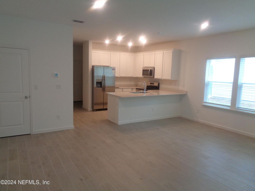 Empty room, Interior, Kitchen, Pendant Lights, Recessed Lighting, Stainless Steel Appliances, Wood Texture Flooring