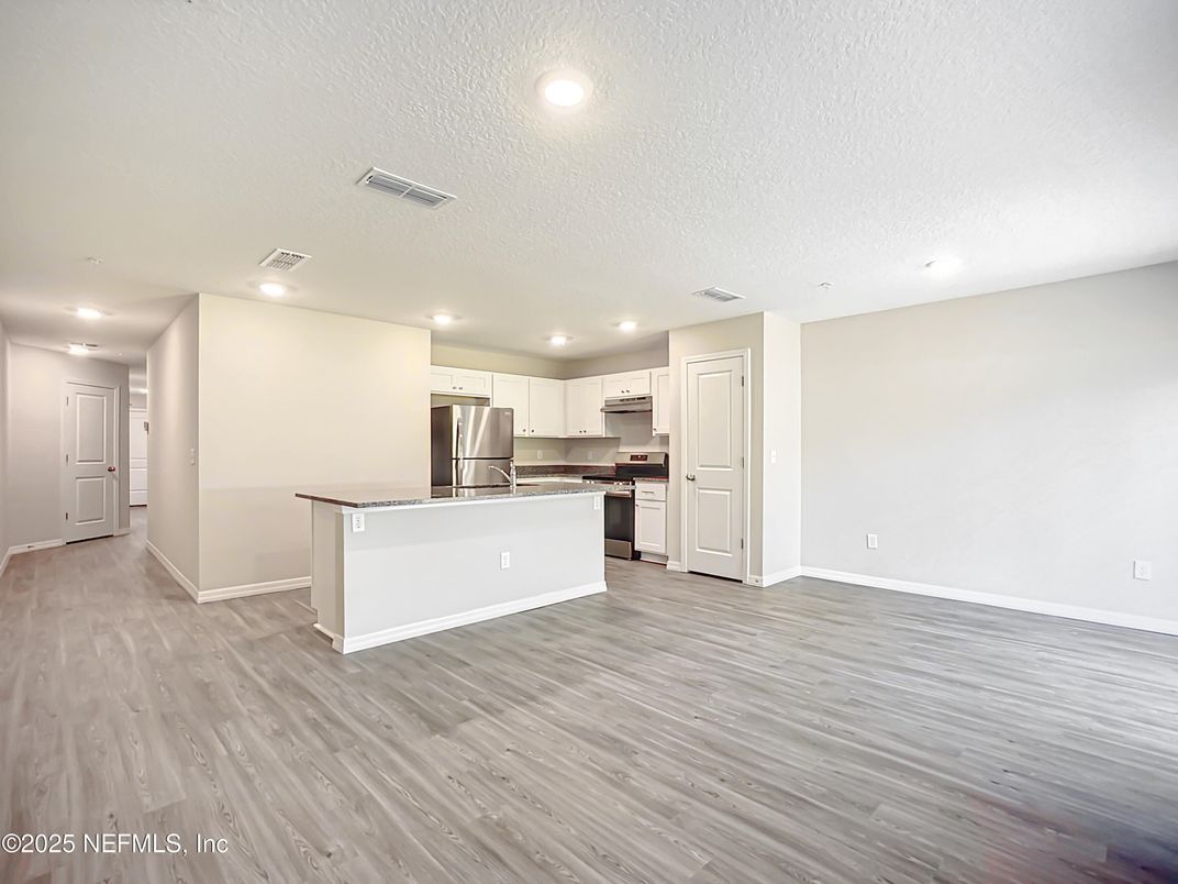 Empty room, Interior, Kitchen, Recessed Lighting, Stainless Steel Appliances, Wood Texture Flooring