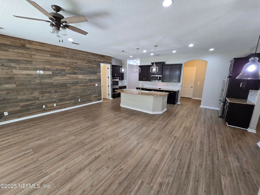 Empty room, Interior, Kitchen, Pendant Lights, Recessed Lighting, Stainless Steel Appliances, Wood Texture Flooring, Wooden Walls