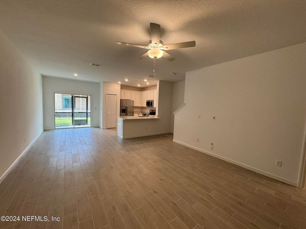 Empty room, Interior, Kitchen, Recessed Lighting, Stainless Steel Appliances, Wood Texture Flooring