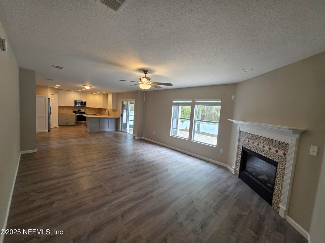Empty room, Fireplace, Interior, Kitchen, Stainless Steel Appliances, Wood Texture Flooring