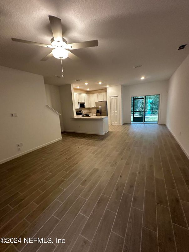 Empty room, Interior, Kitchen, Recessed Lighting, Stainless Steel Appliances, Wood Texture Flooring