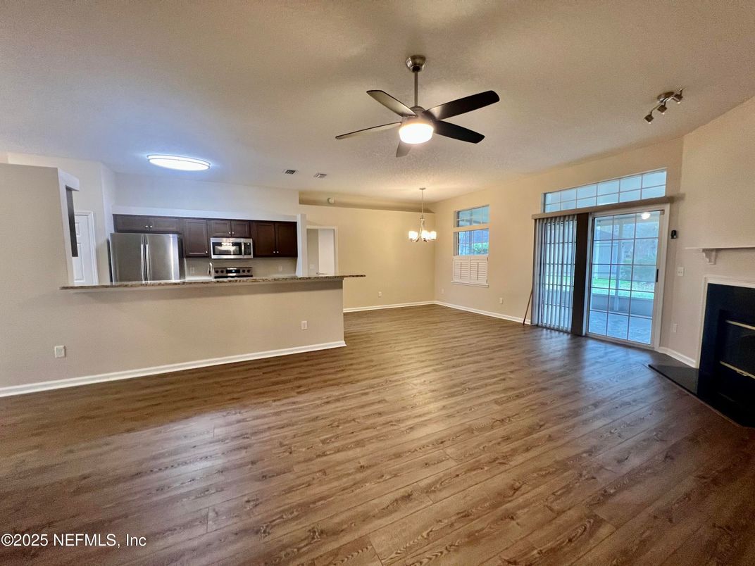 Chandelier, Empty room, Fireplace, Interior, Kitchen, Stainless Steel Appliances, Wood Texture Flooring