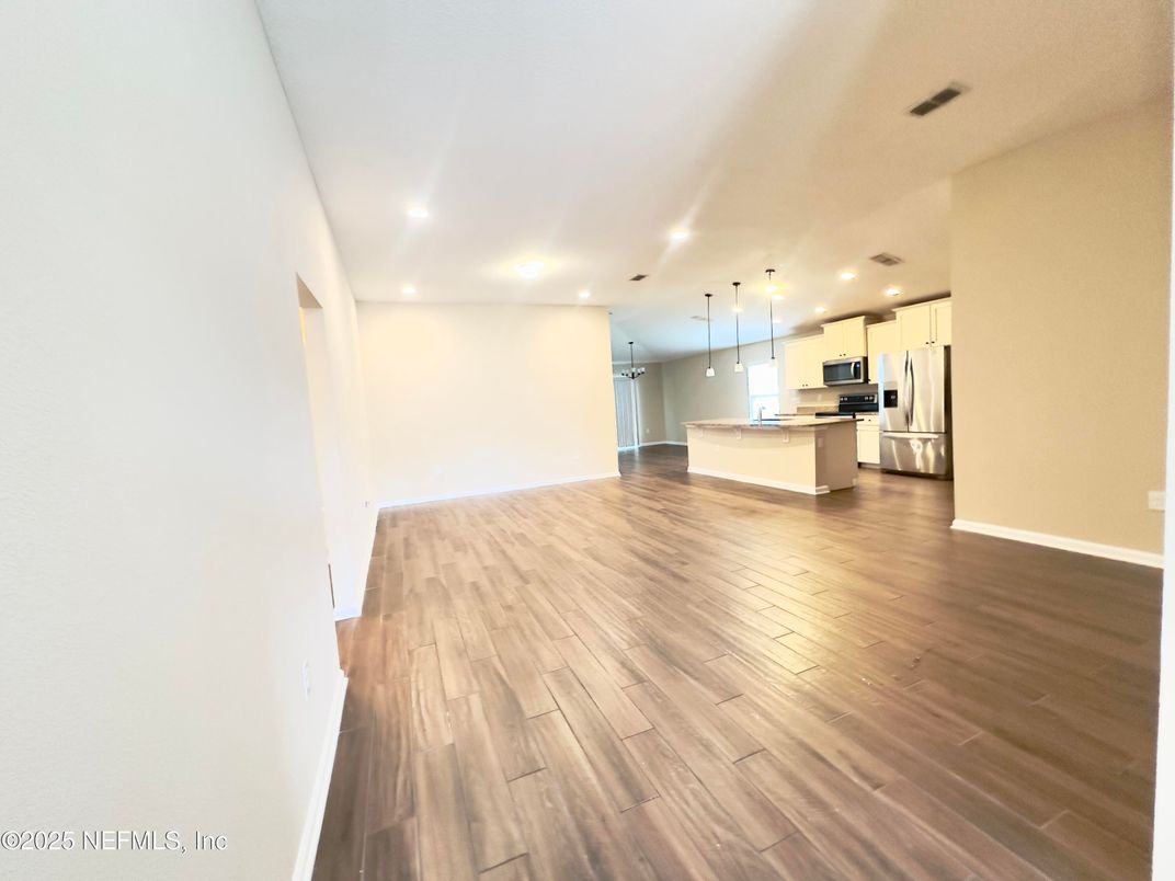 Empty room, Interior, Kitchen, Recessed Lighting, Stainless Steel Appliances, Wood Texture Flooring