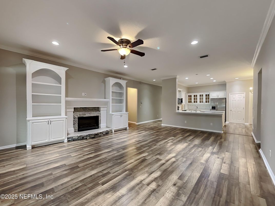 Empty room, Fireplace, Interior, Kitchen, Recessed Lighting, Stainless Steel Appliances, Wood Texture Flooring
