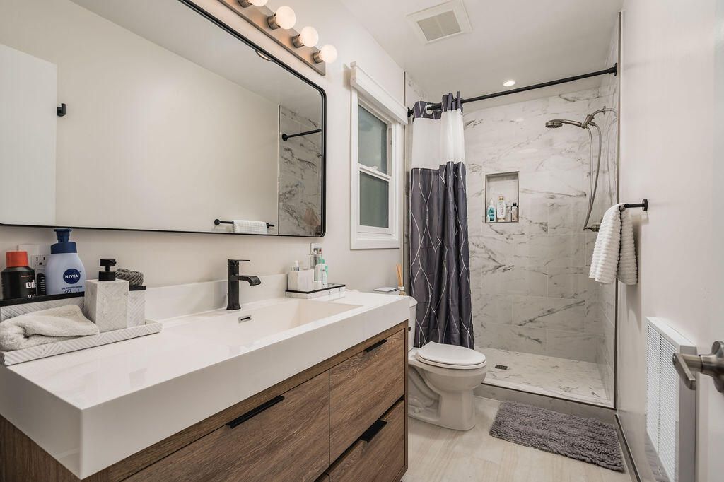 Bathroom, Dual Sink Vanities, Glass Shower, Interior, Marble Walls, Recessed Lighting, Wood Texture Flooring