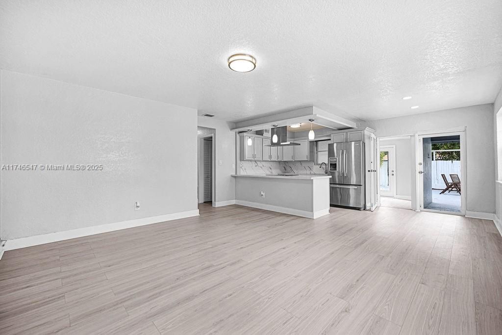 Empty room, Interior, Kitchen, Marble Walls, Recessed Lighting, Stainless Steel Appliances, Wood Texture Flooring
