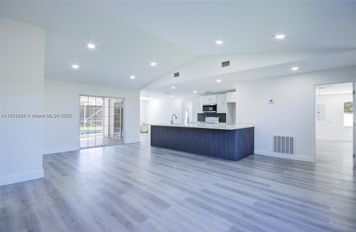 Empty room, Interior, Kitchen, Recessed Lighting, Stainless Steel Appliances, Wood Texture Flooring