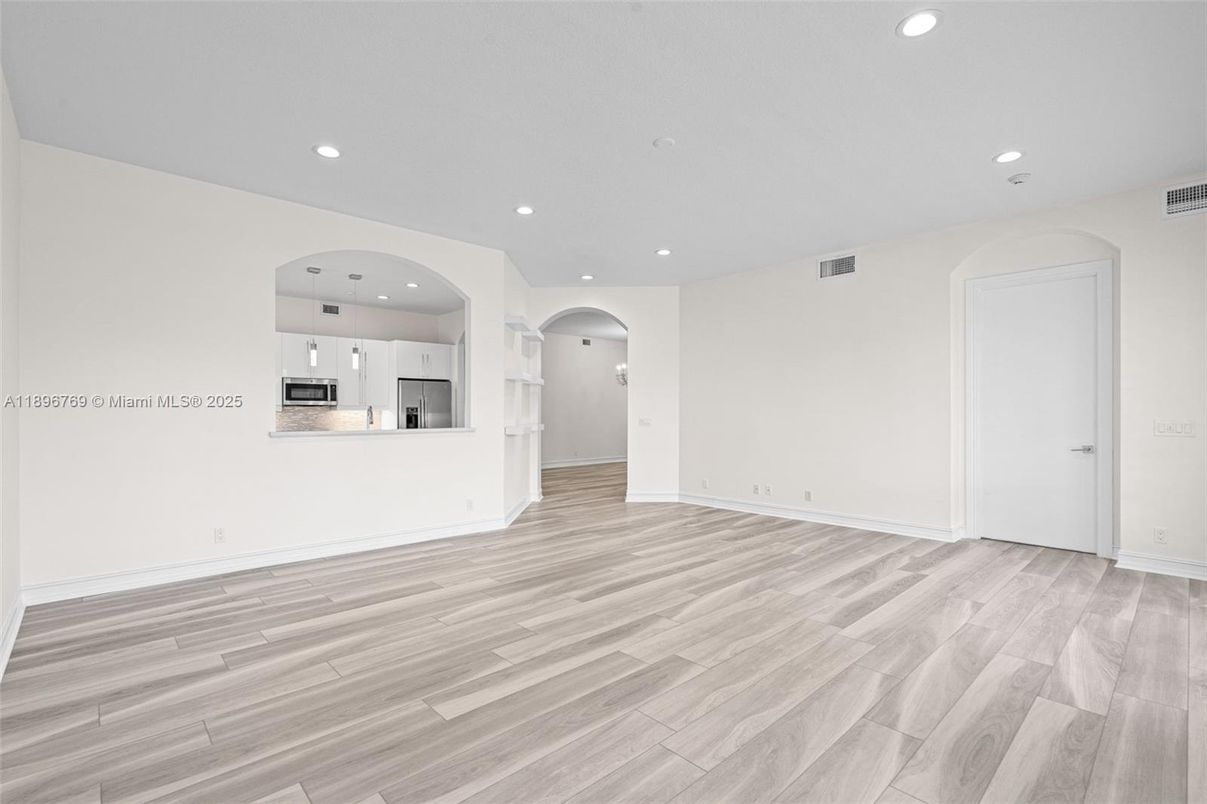 Empty room, Interior, Kitchen, Recessed Lighting, Stainless Steel Appliances, Wood Texture Flooring