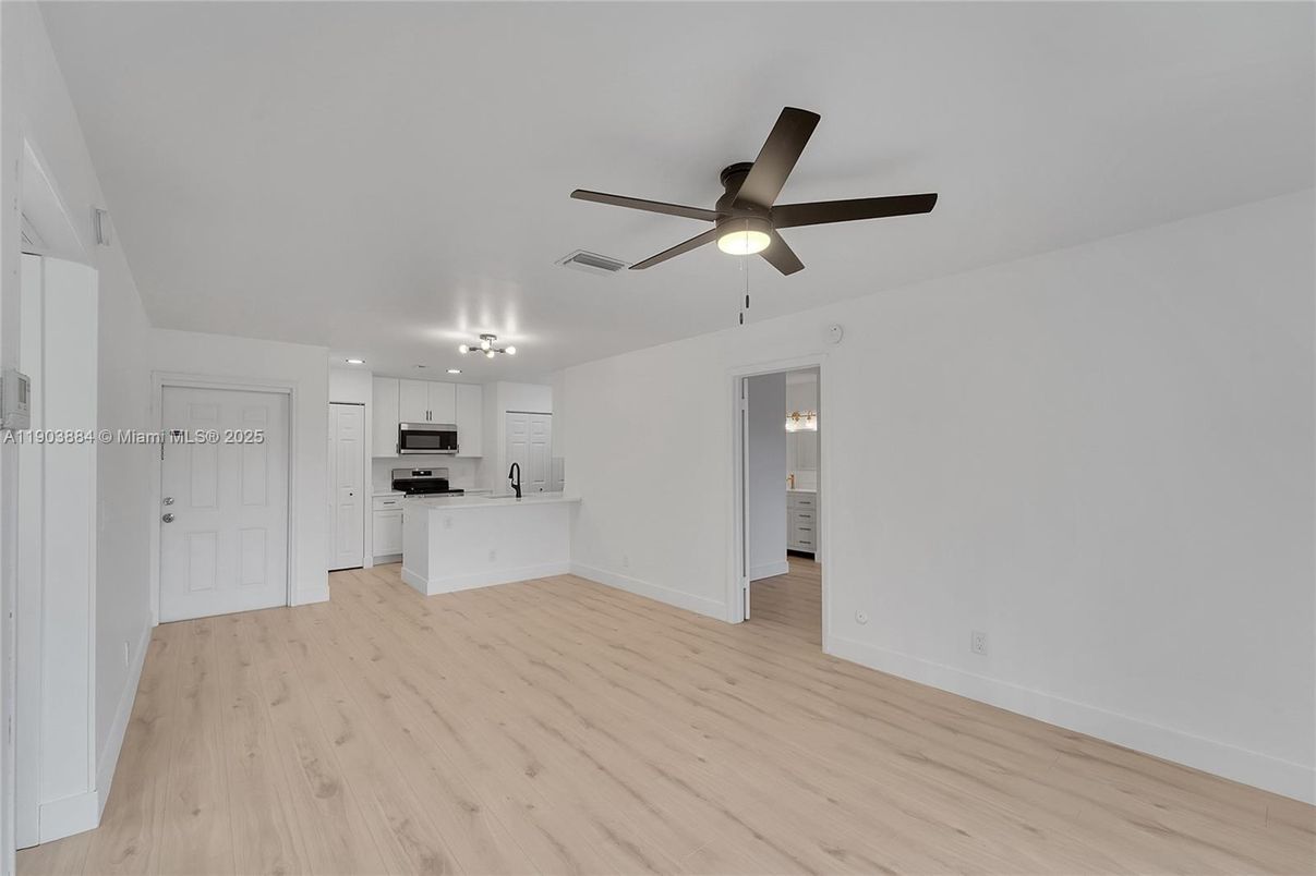 Empty room, Interior, Kitchen, Recessed Lighting, Stainless Steel Appliances, Wood Texture Flooring