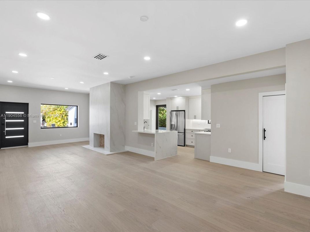 Empty room, Interior, Kitchen, Marble Walls, Recessed Lighting, Stainless Steel Appliances, Wood Texture Flooring