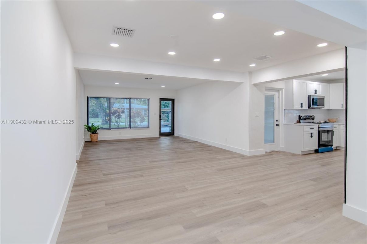 Empty room, Interior, Kitchen, Recessed Lighting, Stainless Steel Appliances, Wood Texture Flooring