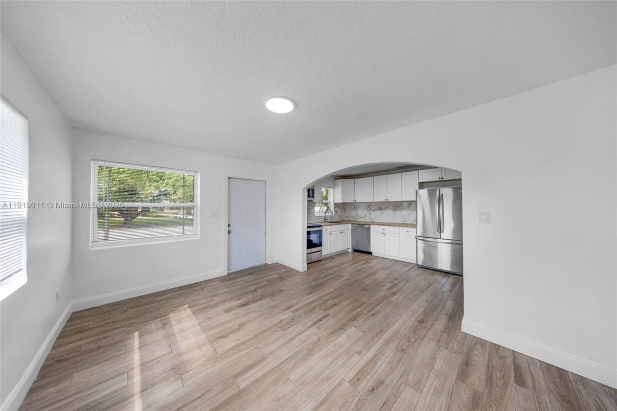 Empty room, Interior, Kitchen, Marble Walls, Recessed Lighting, Stainless Steel Appliances, Wood Texture Flooring