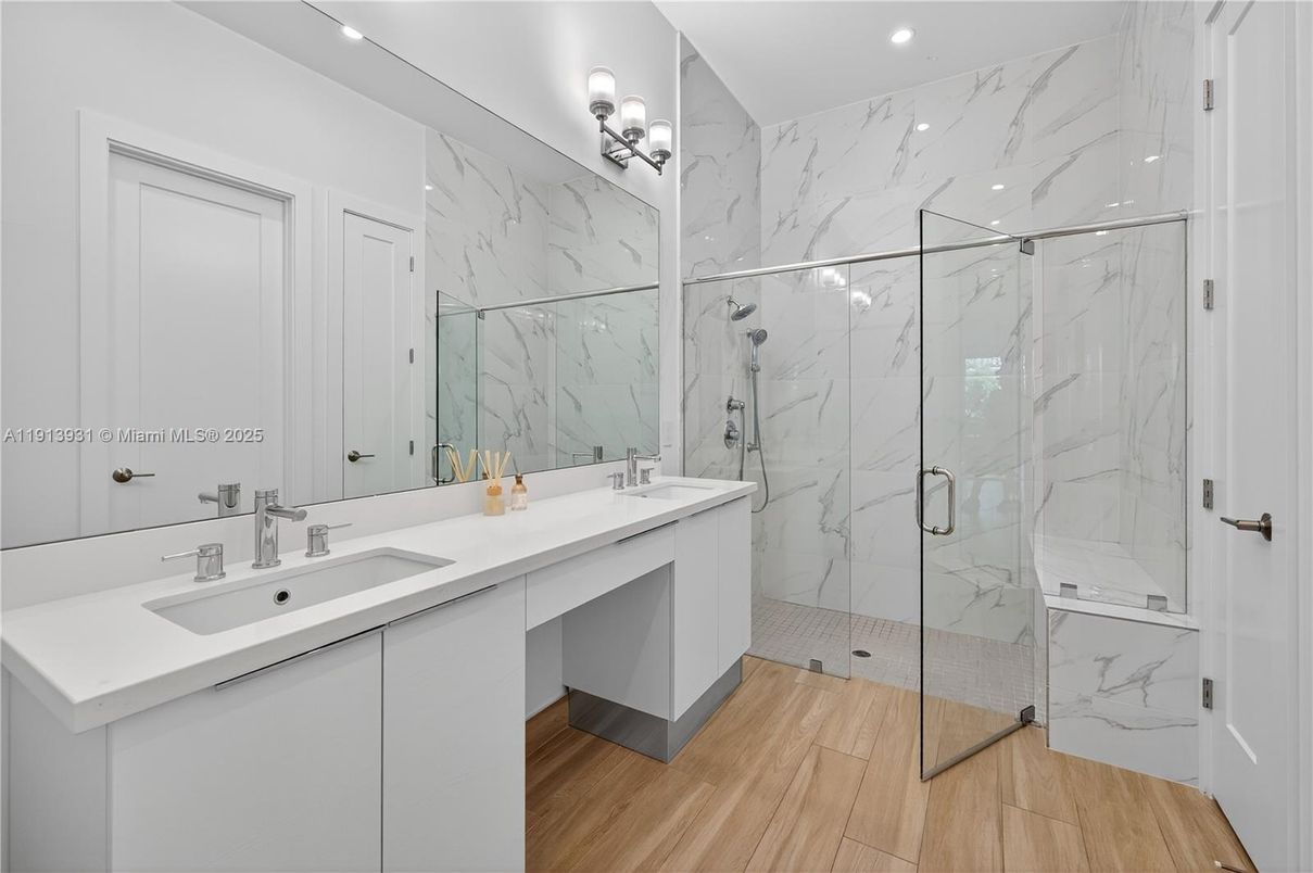 Bathroom, Dual Sink Vanities, Glass Shower, Interior, Marble Walls, Recessed Lighting, Wood Texture Flooring