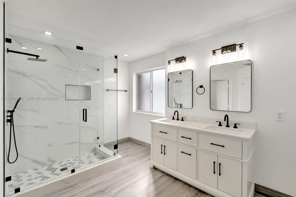 Bathroom, Dual Sink Vanities, Glass Shower, Interior, Marble Walls, Recessed Lighting, Wood Texture Flooring