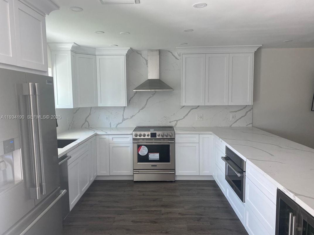 Interior, Kitchen, Marble Walls, Recessed Lighting, Stainless Steel Appliances, Wood Texture Flooring