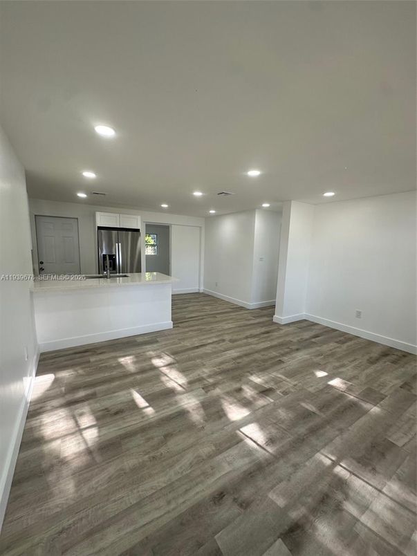 Empty room, Interior, Kitchen, Recessed Lighting, Stainless Steel Appliances, Wood Texture Flooring