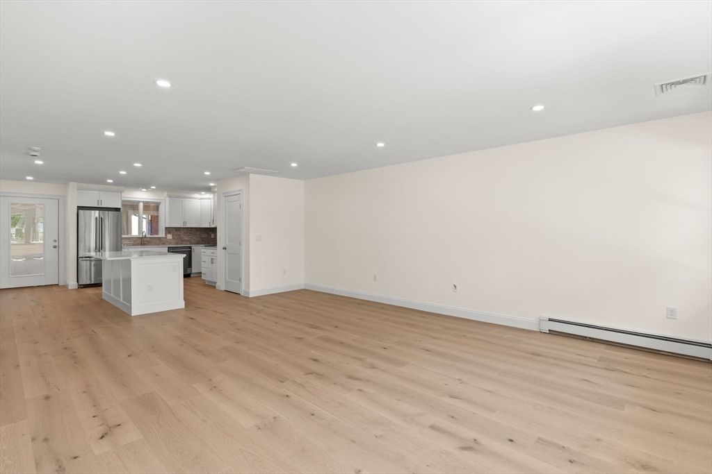 Empty room, Interior, Kitchen, Recessed Lighting, Stainless Steel Appliances, Wood Texture Flooring