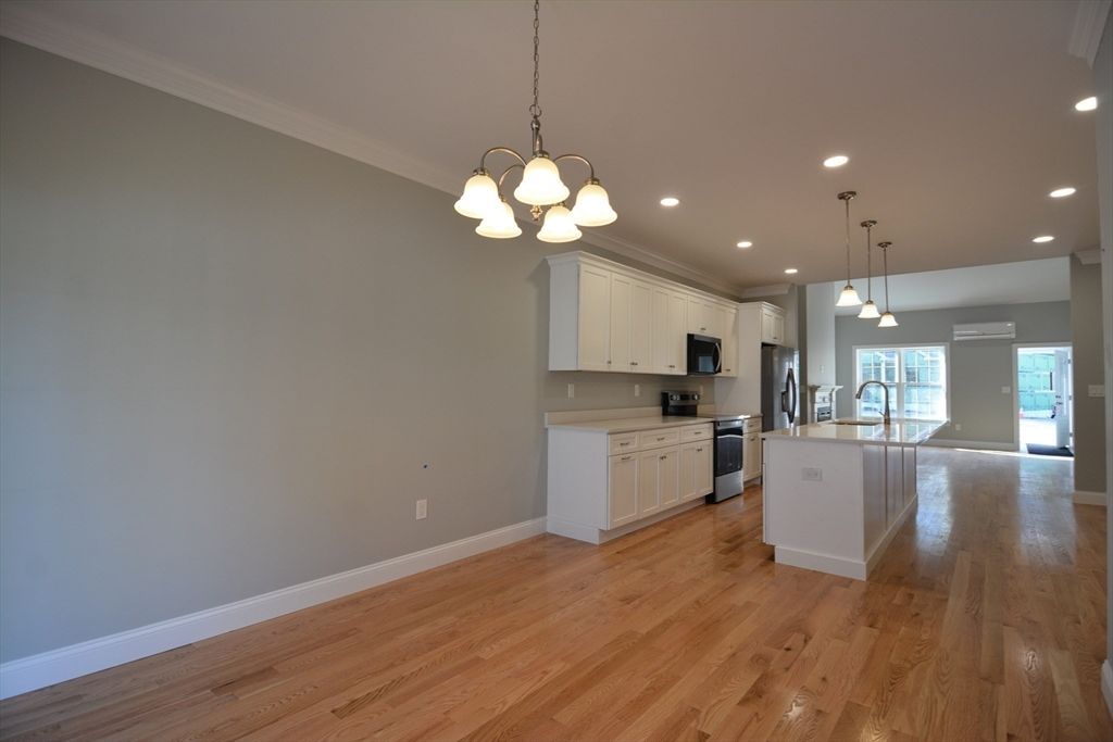 Empty room, Interior, Kitchen, Pendant Lights, Recessed Lighting, Stainless Steel Appliances, Wood Texture Flooring