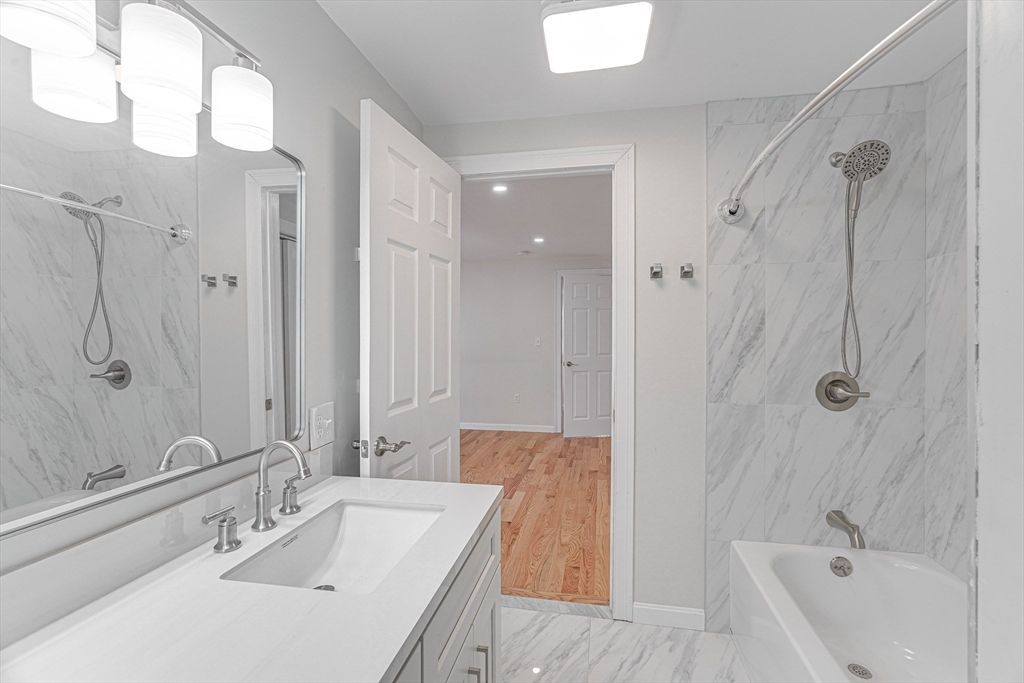 Bathroom, Dual Sink Vanities, Interior, Marble, Marble Walls, Recessed Lighting, Wood Texture Flooring