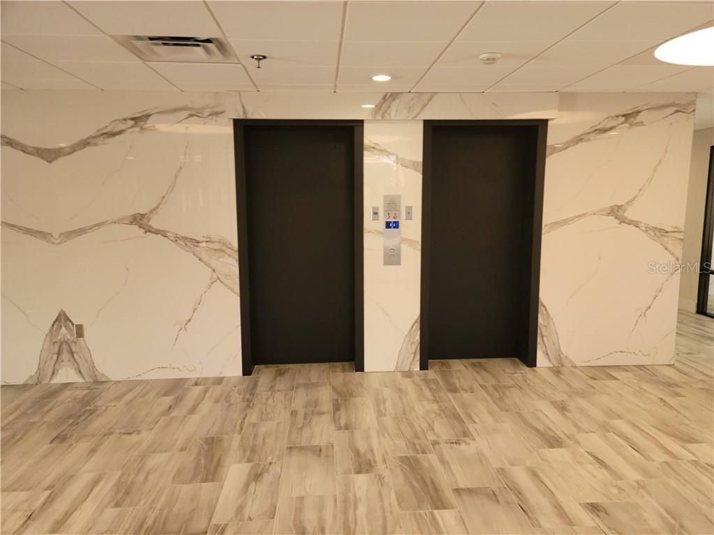 Elevator, Interior, Marble Walls, Recessed Lighting, Wood Texture Flooring