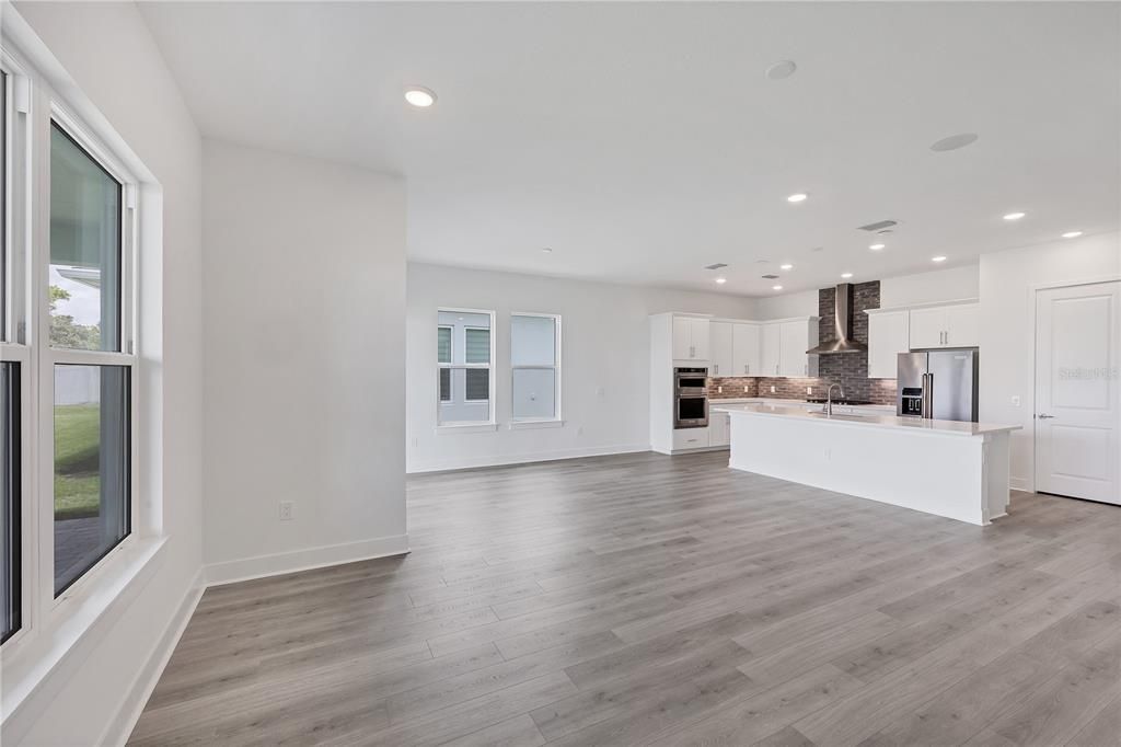Empty room, Interior, Kitchen, Recessed Lighting, Stainless Steel Appliances, Wood Texture Flooring