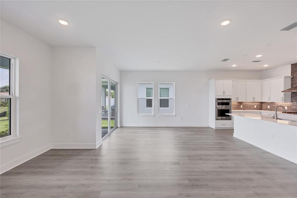 Empty room, Interior, Kitchen, Recessed Lighting, Stainless Steel Appliances, Wood Texture Flooring