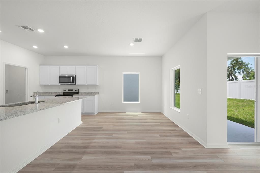 Empty room, Interior, Kitchen, Recessed Lighting, Stainless Steel Appliances, Wood Texture Flooring