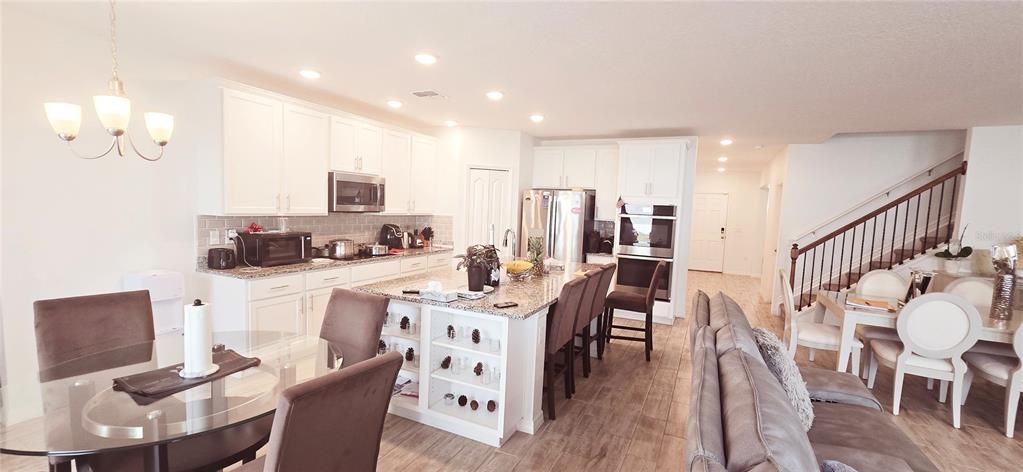 Chandelier, Dining room, Interior, Kitchen, Pendant Lights, Recessed Lighting, Stainless Steel Appliances, Wood Texture Flooring