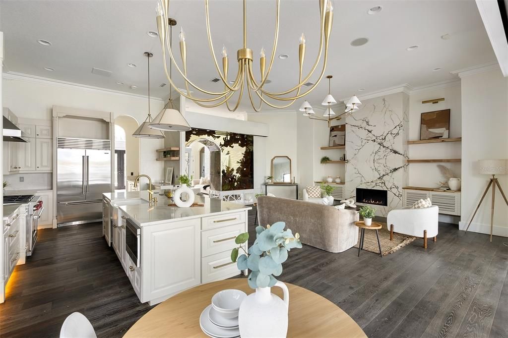 Chandelier, Fireplace, Interior, Kitchen, Living room, Pendant Lights, Recessed Lighting, Stainless Steel Appliances, Wood Texture Flooring