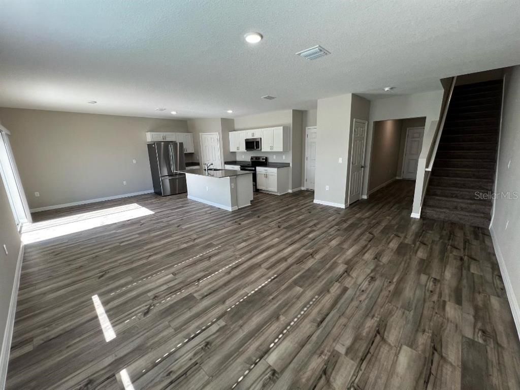 Empty room, Interior, Kitchen, Recessed Lighting, Stainless Steel Appliances, Wood Texture Flooring