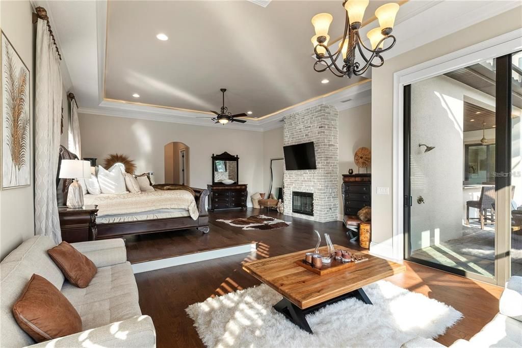 Bedroom, Chandelier, Fireplace, Interior, Recessed Lighting, Stone Walls, Wood Texture Flooring