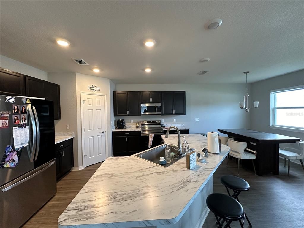 Dining room, Interior, Kitchen, Pendant Lights, Recessed Lighting, Stainless Steel Appliances, Wood Texture Flooring