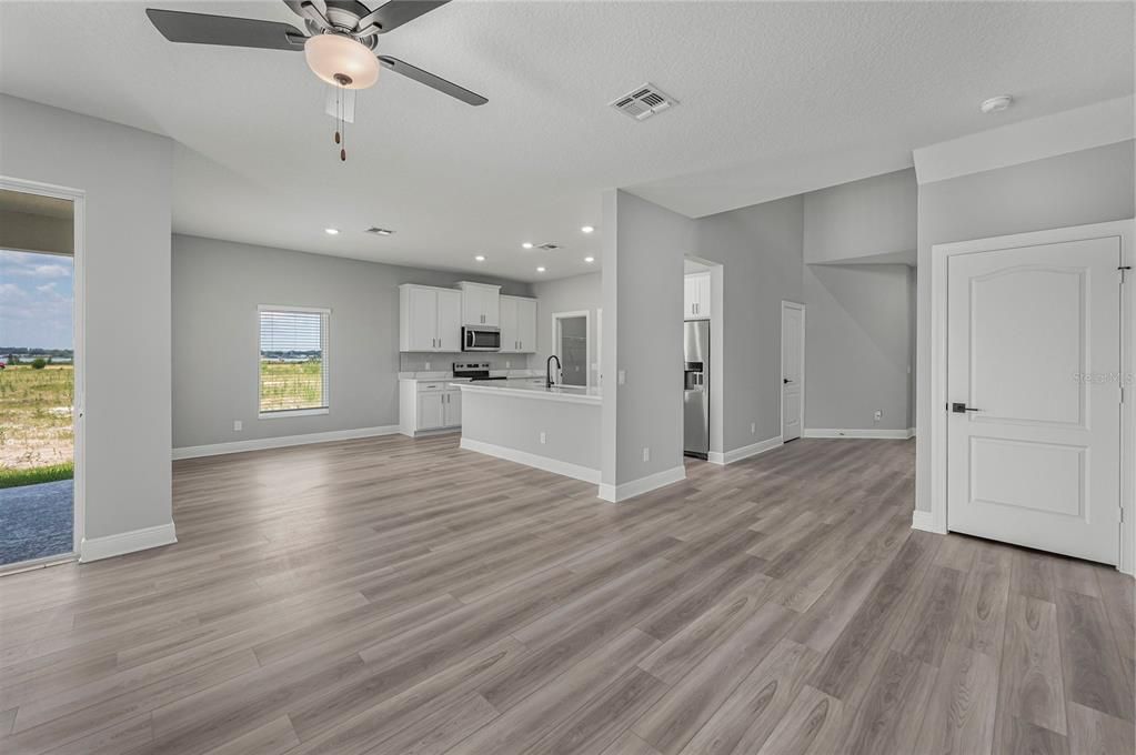 Empty room, Interior, Kitchen, Recessed Lighting, Stainless Steel Appliances, Wood Texture Flooring