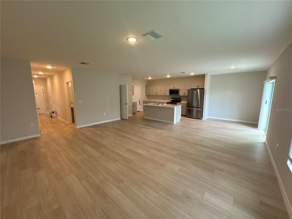 Empty room, Interior, Kitchen, Recessed Lighting, Stainless Steel Appliances, Wood Texture Flooring