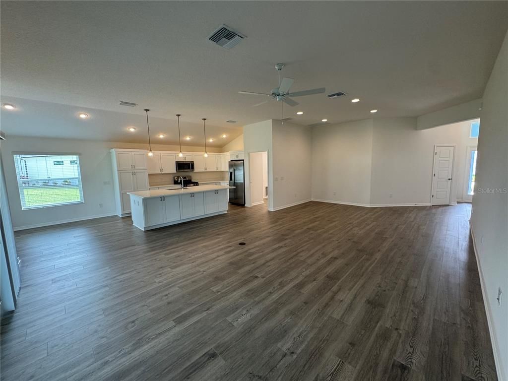 Empty room, Interior, Kitchen, Pendant Lights, Recessed Lighting, Stainless Steel Appliances, Wood Texture Flooring