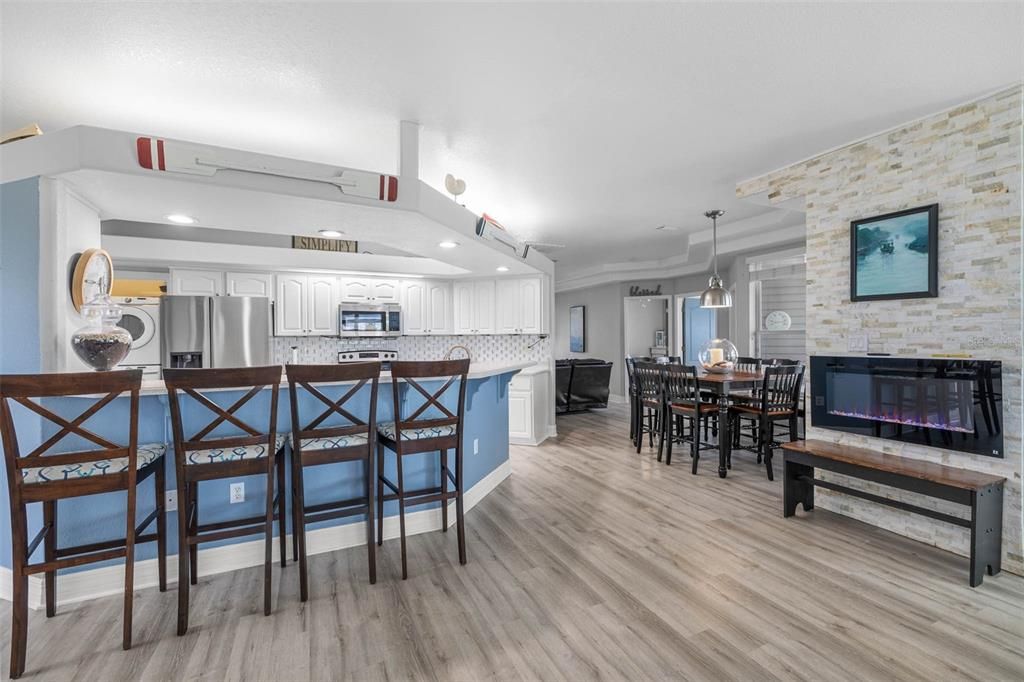 Dining room, Fireplace, Interior, Kitchen, Pendant Lights, Recessed Lighting, Stainless Steel Appliances, Stone Walls, Wood Texture Flooring