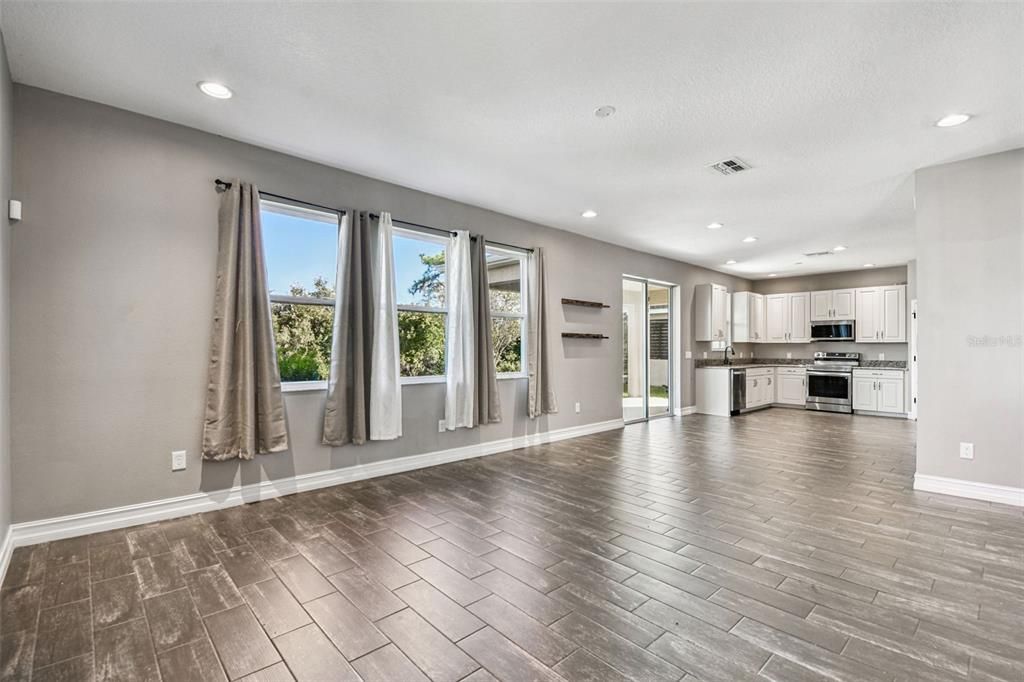 Empty room, Interior, Kitchen, Recessed Lighting, Stainless Steel Appliances, Wood Texture Flooring