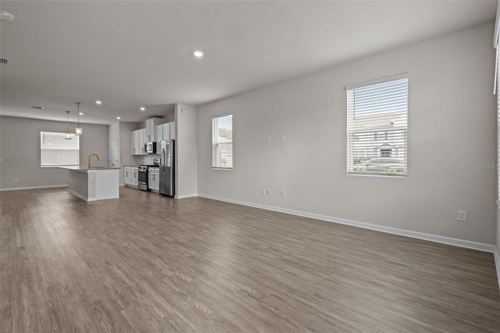 Empty room, Interior, Kitchen, Pendant Lights, Recessed Lighting, Stainless Steel Appliances, Wood Texture Flooring