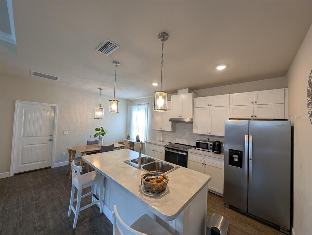 Dining room, Interior, Kitchen, Pendant Lights, Recessed Lighting, Stainless Steel Appliances, Wood Texture Flooring