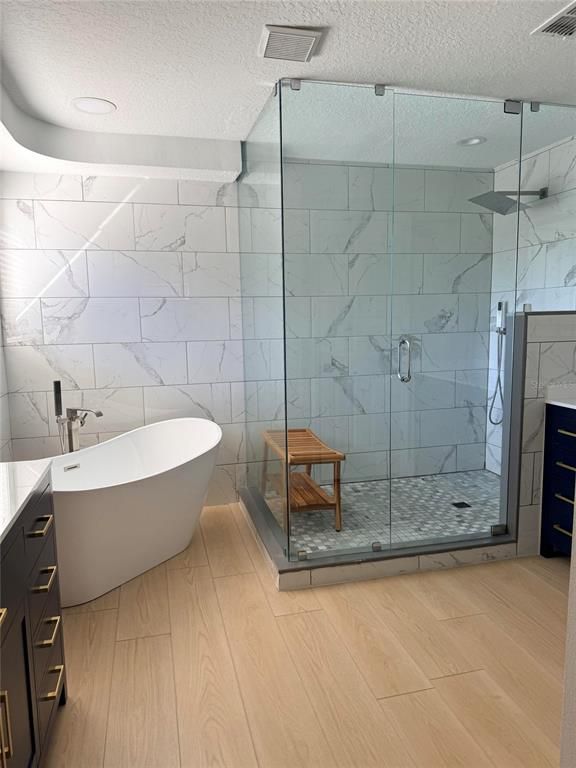 Bathroom, Free Standing Baths, Glass Shower, Interior, Marble Walls, Recessed Lighting, Wood Texture Flooring