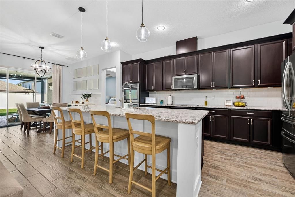 Chandelier, Dining room, Interior, Kitchen, Pendant Lights, Recessed Lighting, Stainless Steel Appliances, Wood Texture Flooring