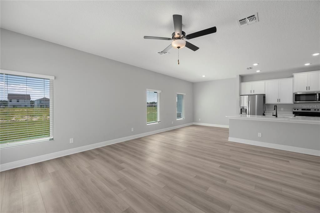 Empty room, Interior, Kitchen, Recessed Lighting, Stainless Steel Appliances, Wood Texture Flooring