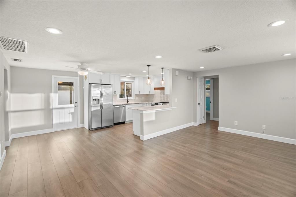 Empty room, Interior, Kitchen, Pendant Lights, Recessed Lighting, Stainless Steel Appliances, Wood Texture Flooring