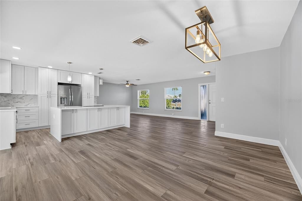 Empty room, Interior, Kitchen, Pendant Lights, Recessed Lighting, Stainless Steel Appliances, Wood Texture Flooring