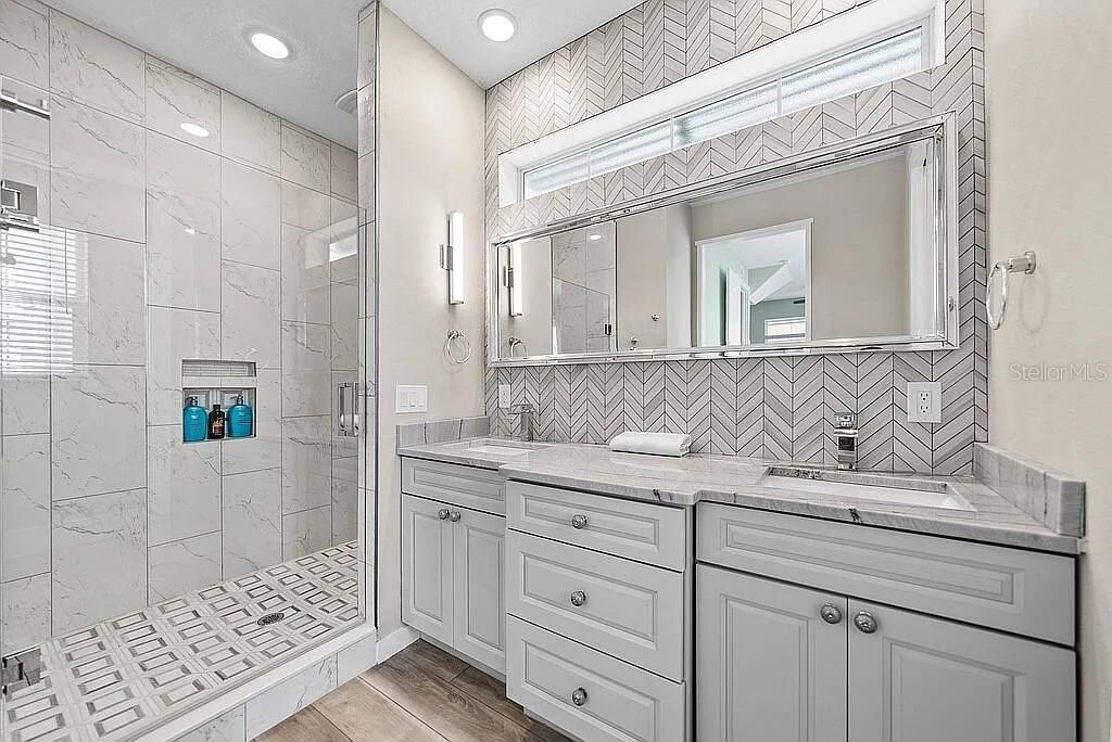 Bathroom, Dual Sink Vanities, Glass Shower, Interior, Marble Walls, Recessed Lighting, Wood Texture Flooring