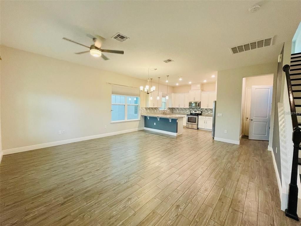 Empty room, Interior, Kitchen, Pendant Lights, Recessed Lighting, Stainless Steel Appliances, Wood Texture Flooring