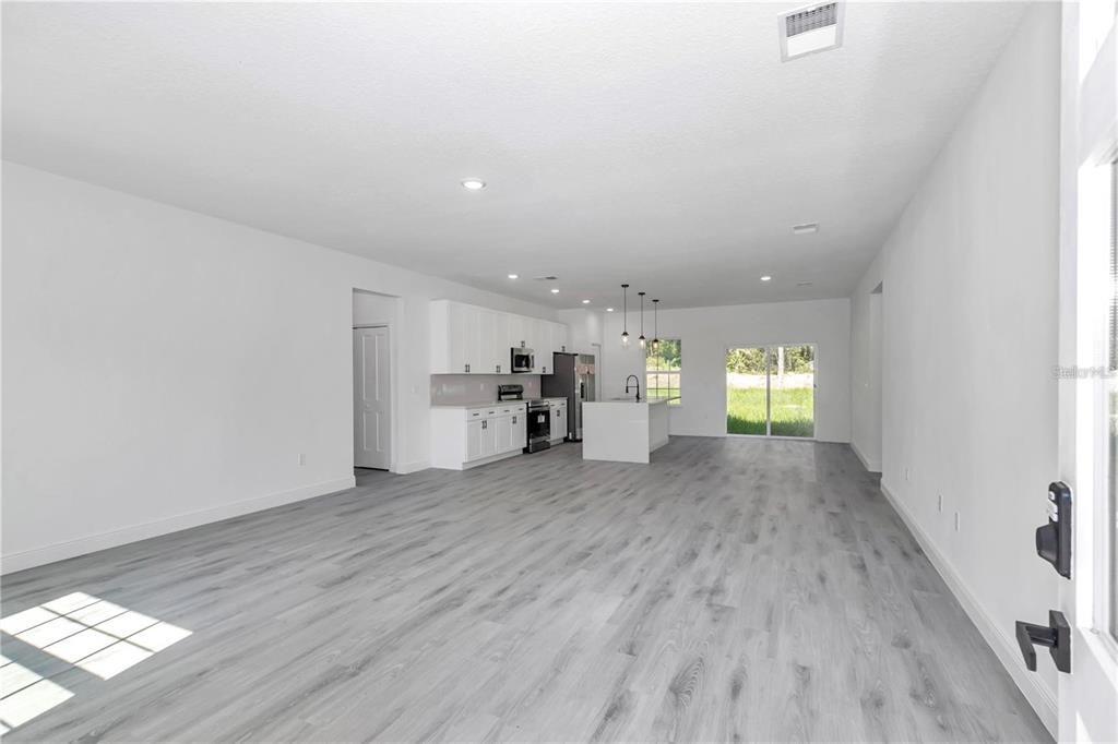Empty room, Interior, Kitchen, Pendant Lights, Recessed Lighting, Stainless Steel Appliances, Wood Texture Flooring