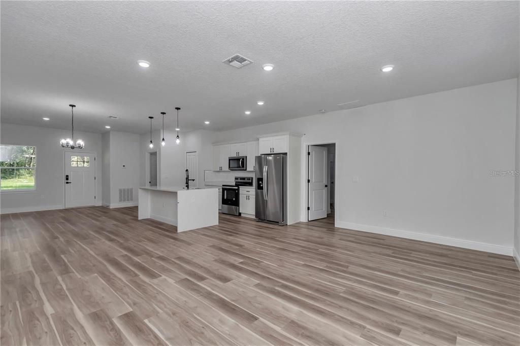 Chandelier, Empty room, Interior, Kitchen, Pendant Lights, Recessed Lighting, Stainless Steel Appliances, Wood Texture Flooring